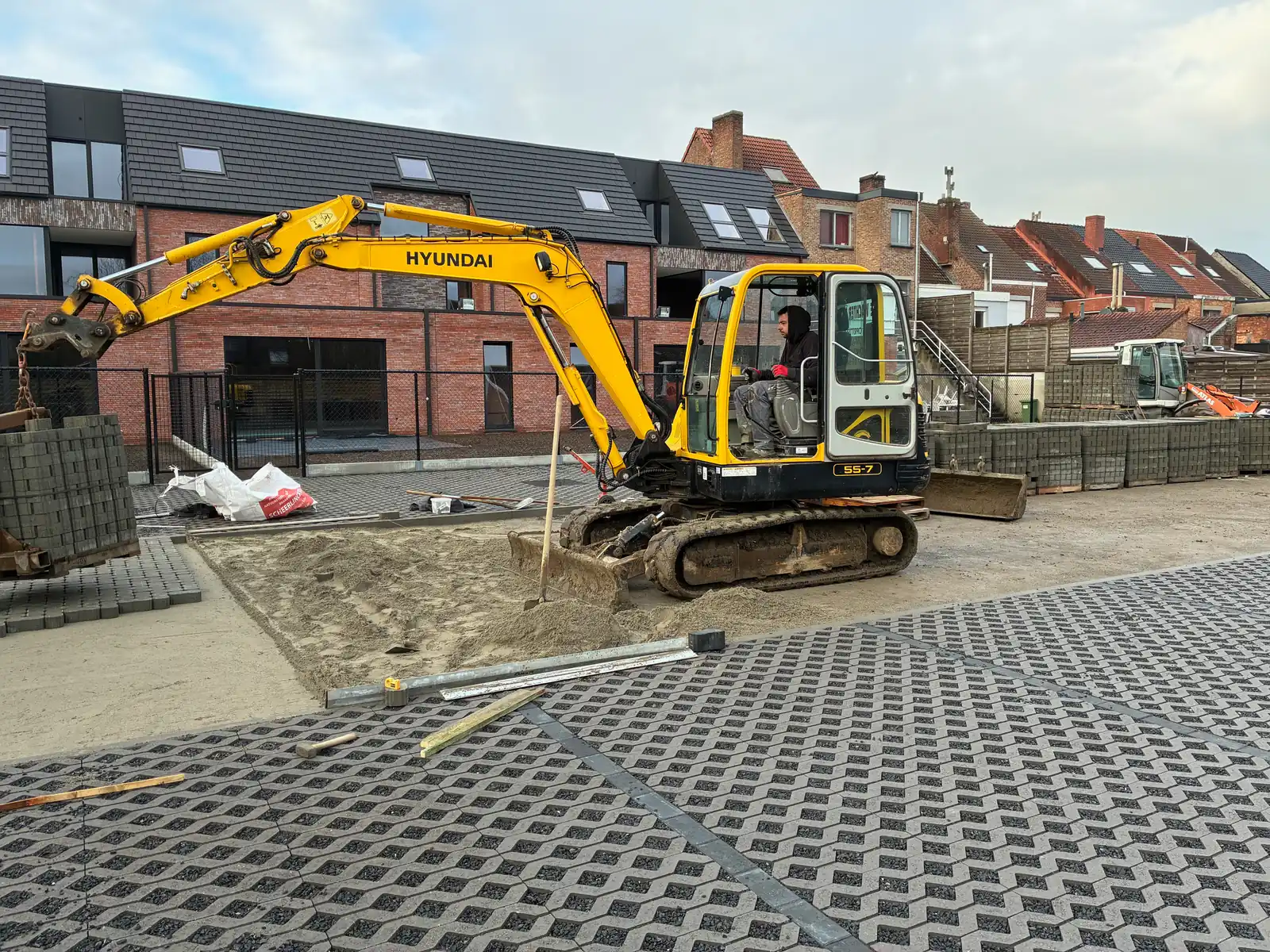 Siebe De Wachter in de cabine van een gele kraan bij een nieuwbouwproject